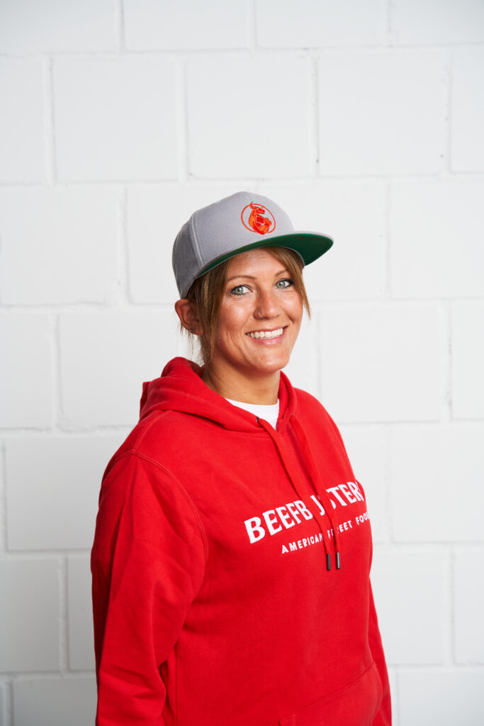 Sales Managerin Sandra im Beefbusters Hoodie, während sie am Telefon ist